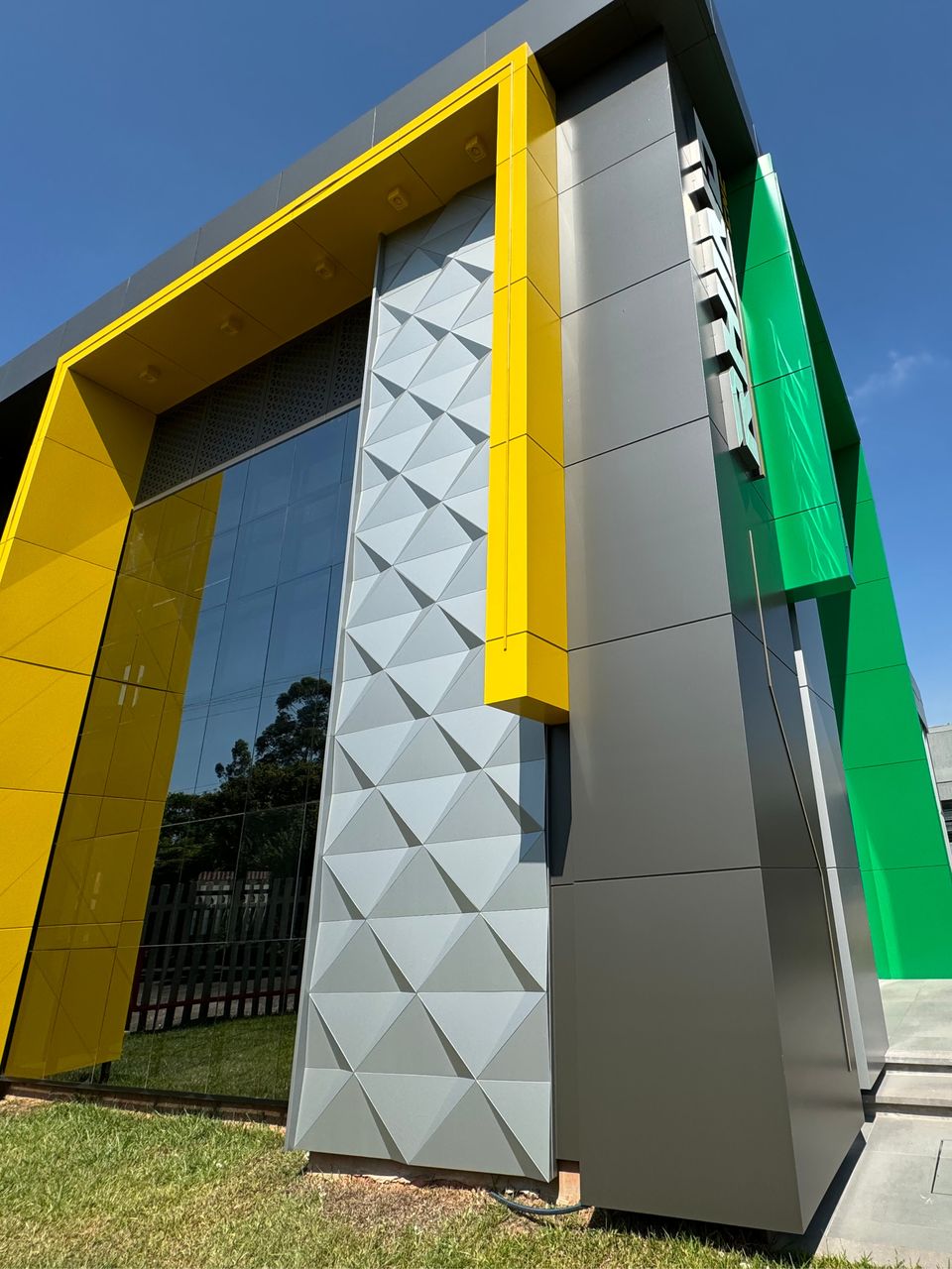 Faceted panels and a green ACM accent